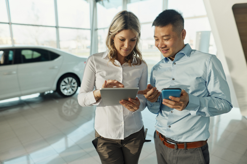 Car dealers on their phone and tablets