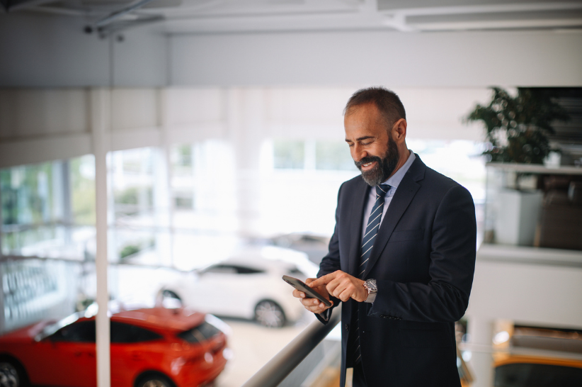 Car dealer looking at phone