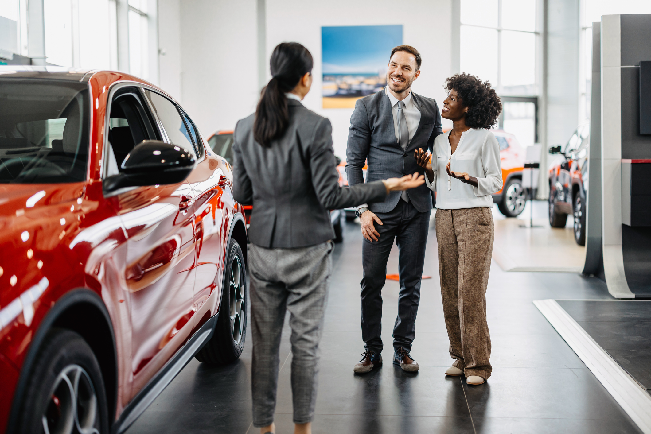 car saleswoman talking to a couple.