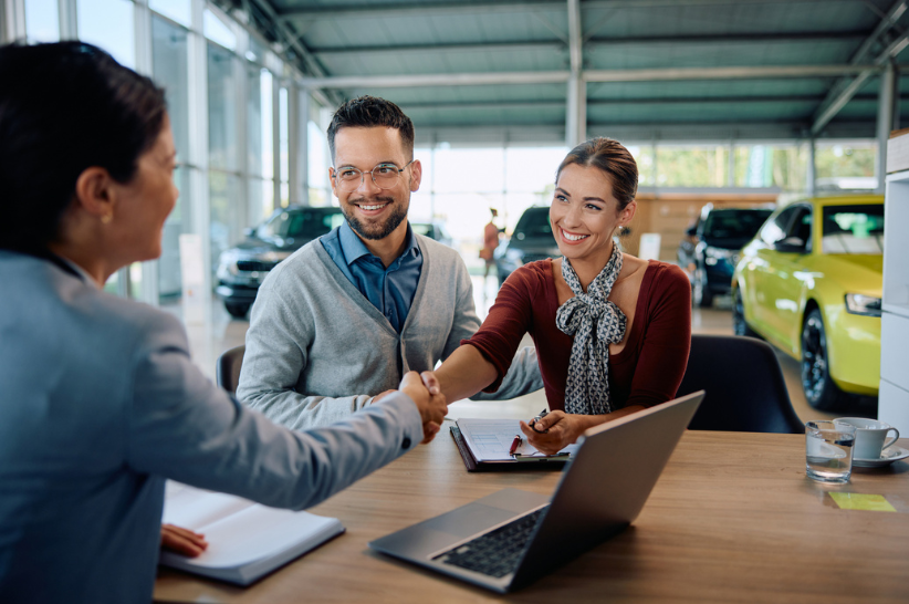 Car dealer shaking his customer's hand
