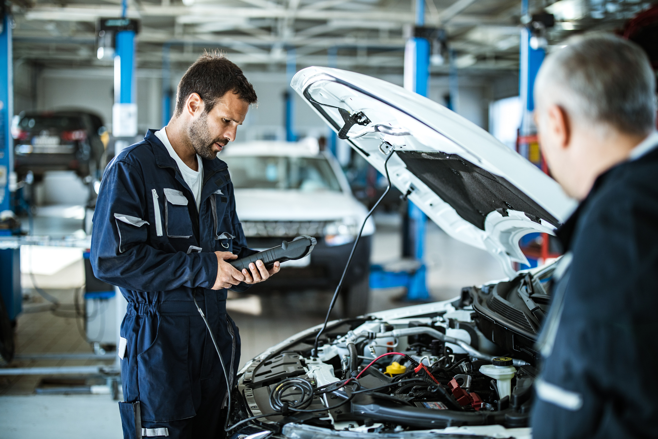 Man inspecting a car in the shop.