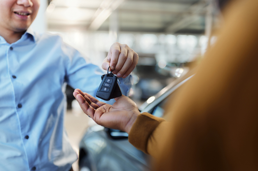 man handing a car key into another hand
